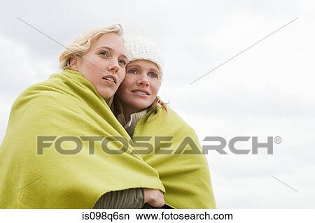 Women sharing a blanket View Large Photo Image Picture - Women sharing a blanket. Fotosearch
