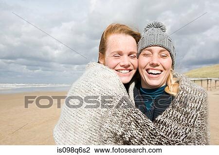 Stock Image - Women sharing a blanket. Fotosearch