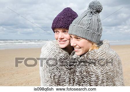 Stock Image - Women sharing a blanket. Fotosearch
