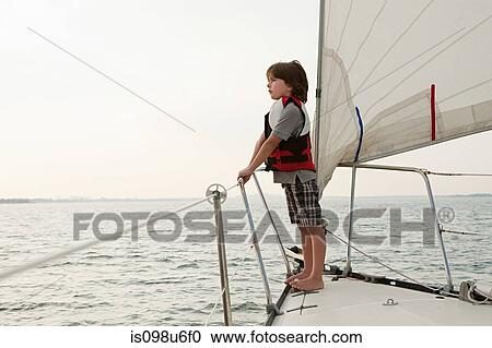 Young boy on board yacht, looking at view View Large Photo Image Stock Image - Young boy on board yacht, looking at view. Fotosearch