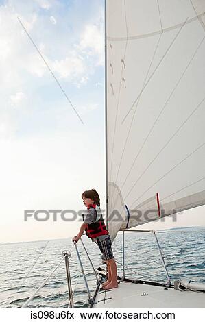 Young boy on board yacht, looking at view View Large Photo Image Stock Photo - Young boy on board yacht, looking at view. Fotosearch