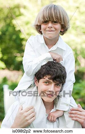 Young boy on shoulders of older boy View Large Photo Image Stock Image - Young boy on shoulders of older boy. Fotosearch
