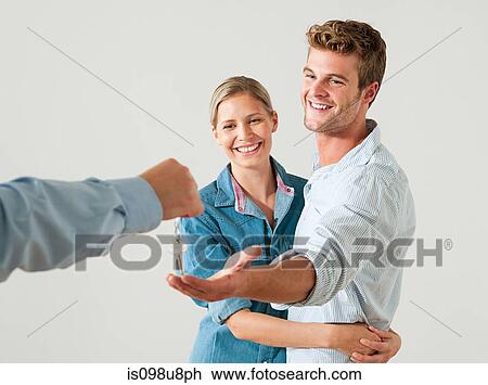 Young couple being handed house keys View Large Photo Image Stock Image - Young couple being handed house keys. Fotosearch
