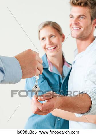Young couple being handed house keys View Large Photo Image Stock Photography - Young couple being handed house keys. Fotosearch