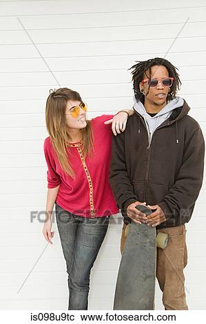 Young couple by wall View Large Photo Image Stock Image - Young couple by wall. Fotosearch