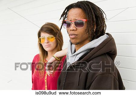 Stock Image - Young couple by wall. Fotosearch