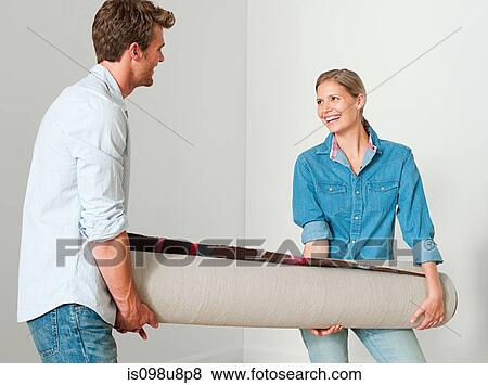 Young couple carrying a rolled up rug View Large Photo Image Stock Photo - Young couple carrying a rolled up rug. Fotosearch