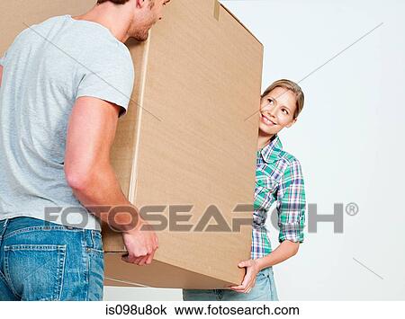 Stock Image - Young couple carrying cardboard box. Fotosearch