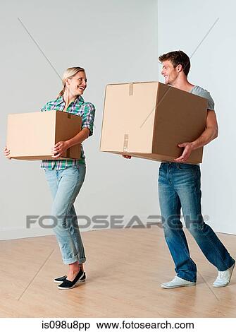 Stock Photography - Young couple carrying cardboard boxes. Fotosearch