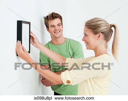 Young couple hanging a picture View Large Photo Image Stock Image - Young couple hanging a picture. Fotosearch