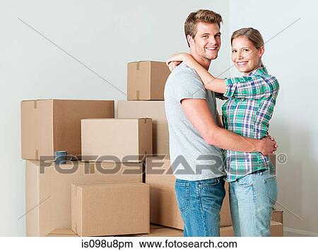 Young couple hugging by cardboard boxes View Large Photo Image Picture - Young couple hugging by cardboard boxes. Fotosearch