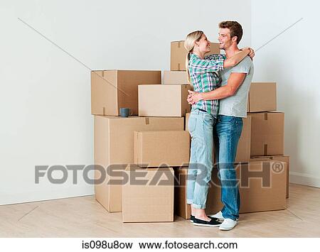 Young couple hugging by cardboard boxes View Large Photo Image Stock Photo - Young couple hugging by cardboard boxes. Fotosearch
