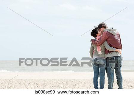 Young couple kissing by the sea View Large Photo Image Stock Photo - Young couple kissing by the sea. Fotosearch