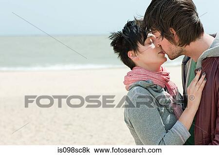 Young couple kissing on a beach View Large Photo Image Stock Image - Young couple kissing on a beach. Fotosearch