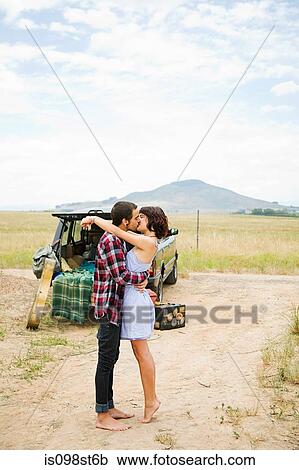 Stock Image - Young couple kissing outdoors. Fotosearch