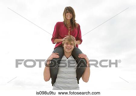 Young couple, man carrying girl on shoulders View Large Photo Image Stock Photograph - Young couple, man carrying girl on shoulders. Fotosearch
