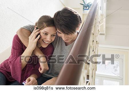 Stock Photograph - Young couple sat on steps. Fotosearch