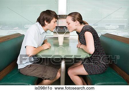 Young couple sharing a milkshake View Large Photo Image Picture - Young couple sharing a milkshake. Fotosearch