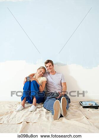 Picture - Young couple taking a break from decorating. Fotosearch