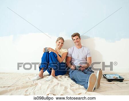 Young couple taking a break from painting View Large Photo Image Picture - Young couple taking a break from painting. Fotosearch