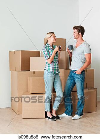 Stock Photo - Young couple taking a break from unpacking. Fotosearch