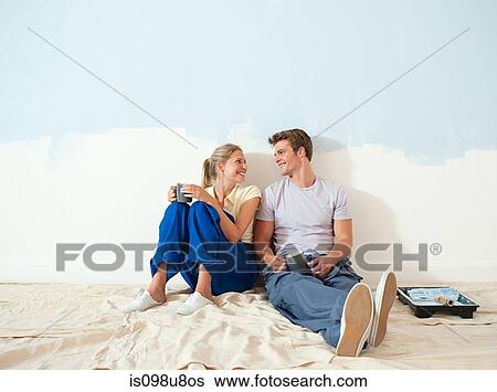 Young couple taking a break from decorating View Large Photo Image Stock Photograph - Young couple taking a break from decorating. Fotosearch