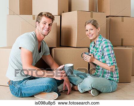 Young couple taking a break from unpacking View Large Photo Image Stock Photography - Young couple taking a break from unpacking. Fotosearch