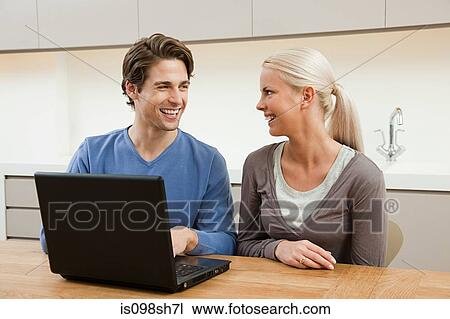 Young couple using laptop View Large Photo Image Stock Image - Young couple using laptop. Fotosearch