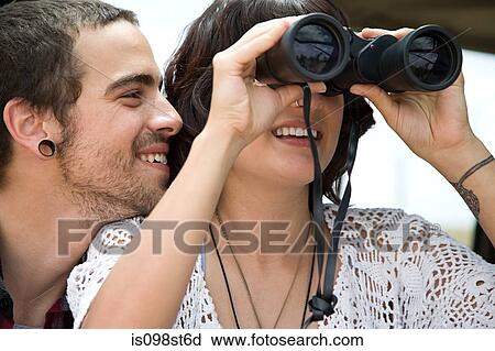 Stock Image - Young couple with binoculars. Fotosearch