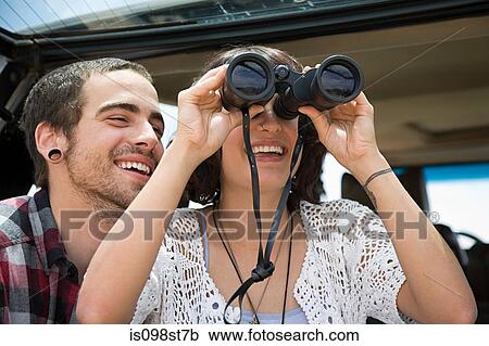 Stock Image - Young couple with binoculars. Fotosearch