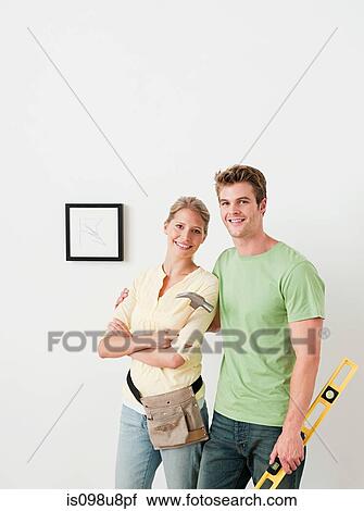 Young couple with tools picture on wall View Large Photo Image Stock Image - Young couple with tools picture on wall. Fotosearch
