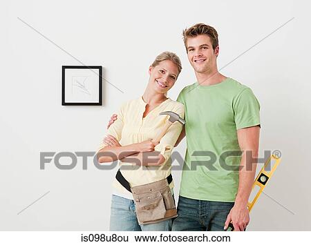 Young couple with tools picture on wall View Large Photo Image Stock Photograph - Young couple with tools picture on wall. Fotosearch