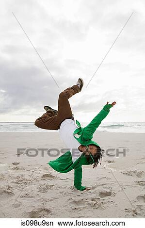 Young man doing cartwheels on beach View Large Photo Image Picture - Young man doing cartwheels on beach. Fotosearch