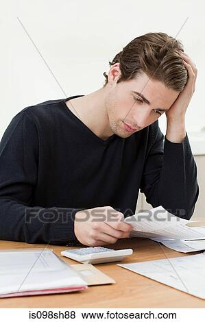 Stock Photo - Young man doing paperwork. Fotosearch