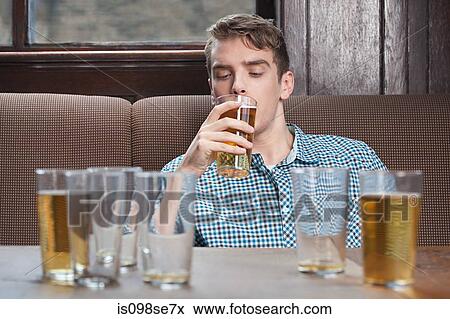 Young man drinking beer in bar View Large Photo Image Stock Photo - Young man drinking beer in bar. Fotosearch