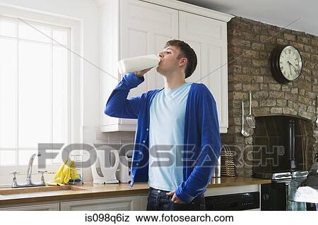Young man drinking milk View Large Photo Image Stock Photo - Young man drinking milk. Fotosearch