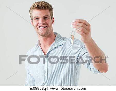 Young man holding house keys View Large Photo Image Picture - Young man holding house keys. Fotosearch
