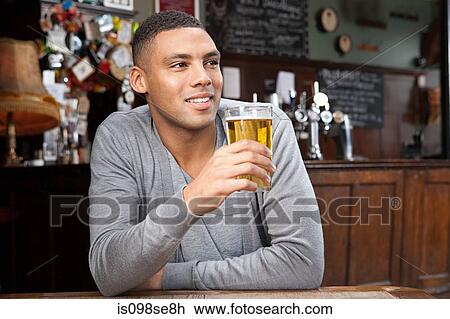 Stock Image - Young man in bar. Fotosearch
