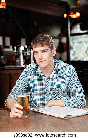 Stock Image - Young man in bar. Fotosearch