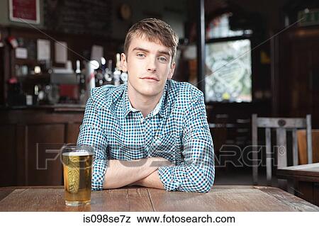 Stock Photo - Young man in bar. Fotosearch