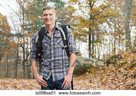 Young man in forest with backpack View Large Photo Image Stock Image - Young man in forest with backpack. Fotosearch