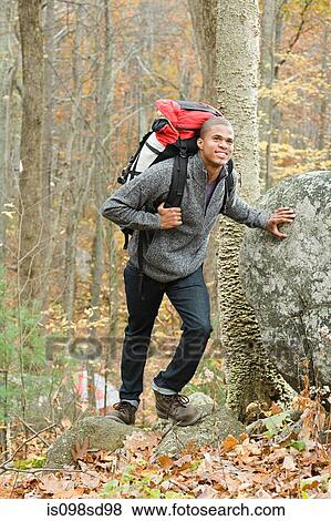 Young man in forest with backpack View Large Photo Image Stock Photo - Young man in forest with backpack. Fotosearch