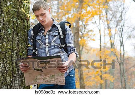 Young man looking at map View Large Photo Image Stock Photo - Young man looking at map. Fotosearch