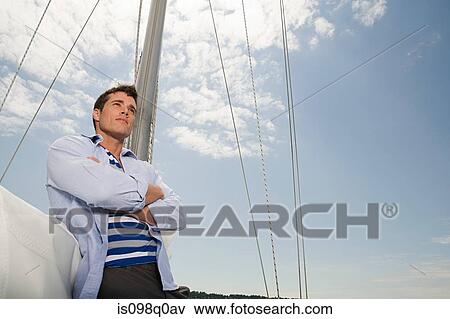 Stock Photo - Young man on a sailing boat. Fotosearch