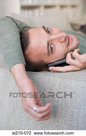 Stock Image - Young man on cellphone. Fotosearch