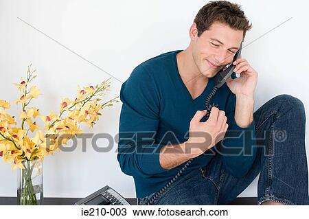 Stock Image - Young man on telephone. Fotosearch