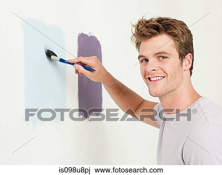 Stock Image - Young man painting a wall. Fotosearch