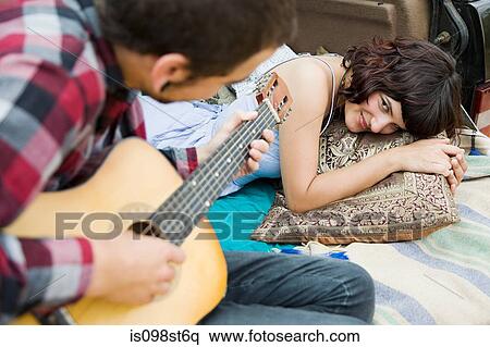 Young man playing guitar to girlfriend View Large Photo Image Stock Photography - Young man playing guitar to girlfriend. Fotosearch