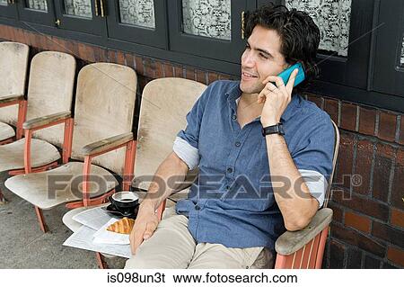 Stock Photograph - Young man using cellphone. Fotosearch