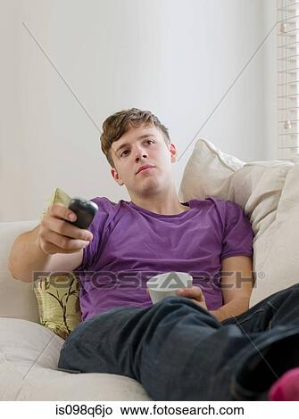 Young man watching tv View Large Photo Image Picture - Young man watching tv. Fotosearch